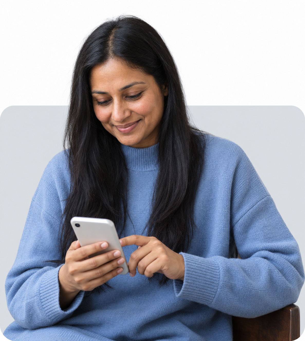 A woman smiling at a message from her care team on her phone